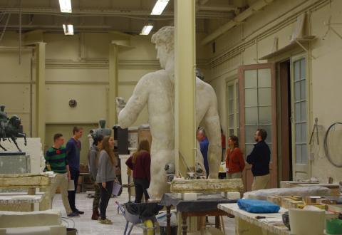 groupe en visite à l'atelier de moulages avec un guide